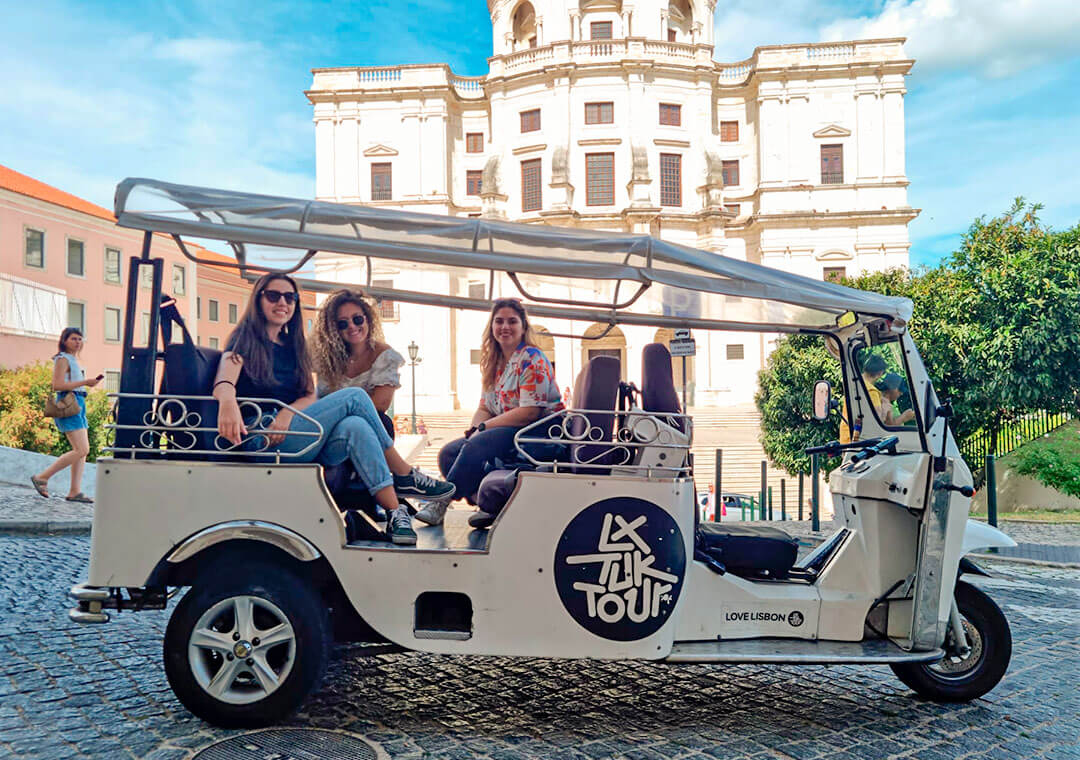 A group of tourists in Lisbon an a tuk tuk.